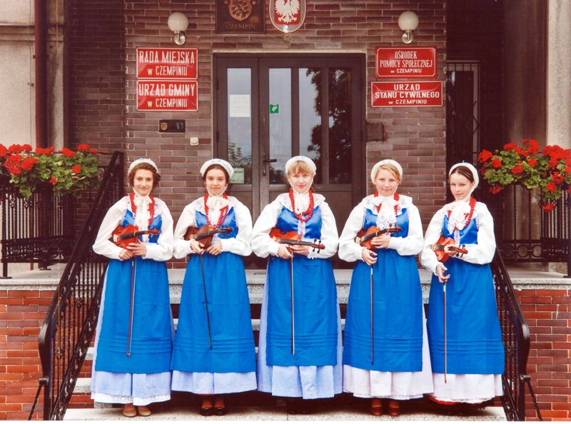 Pięć człlonkiń młodzieżowej kapeli dudziarskiej w strojach ludowych ze skrzypcami w sołectwie Stary Gołębin, w gminie Czempiń