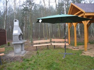 Parasol ogrodowy, grill betonowy i ławki przy świetlicy wiejskiej w sołectwie Dziadowice-Folwark, w gminie Malanów