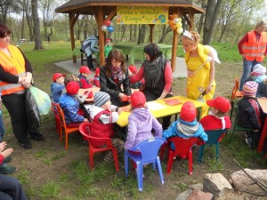 Dzieci siedzące prz stolikach podczas zabawy animacyjnej zorganizowanej w zabytkowym parku w Słowikowie, w gminie Orchowo