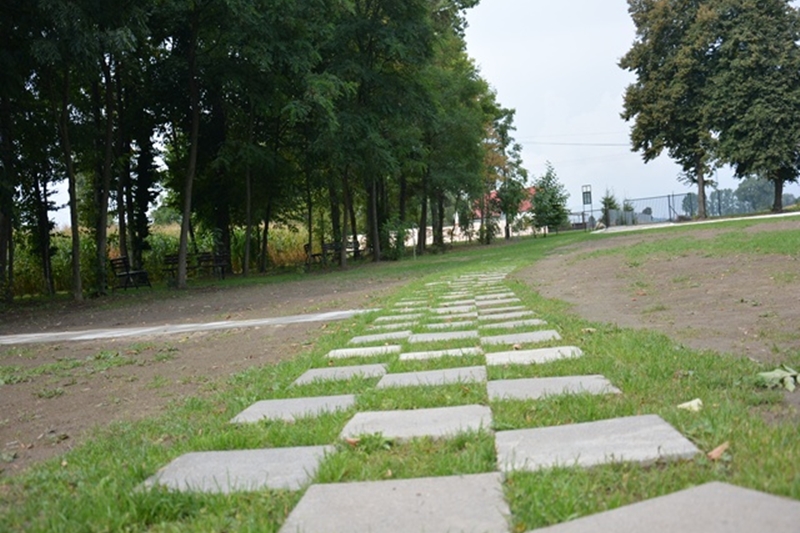 Alejka spacerowa wykonana z płyt betonowych i trawy w Srebrnej Górze, w gminie Wapno