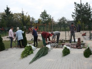 Mieszkańcy dokonujący nasadzeń krzewów przy utwardzonym placu i w pobliżu placu zabaw w Wszemborzu, w gminie Kołaczkowo