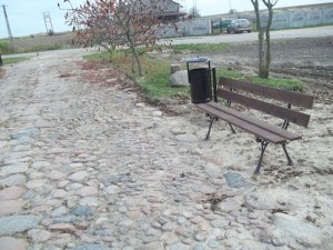 Nowa ławka i kosz na śmieci przy kamiennej ścieżce w Popielewie II, w gminie Skulsk