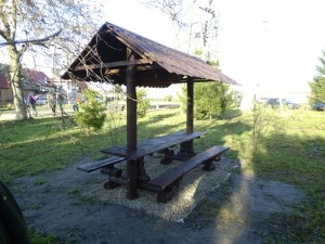 Drewniany, zadaszony ławostół w zabytkowym parku w sołectwie Skic, w gminie Złotów