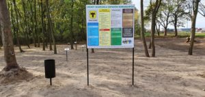 Tablica informująca o zasadach segregacji odpadów w zagajniku leśnym w sołectwie Żbiki, w gminie Czermin